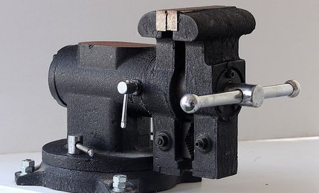 Rotating crank attached to a mechanical device with two flat edges touching each other.